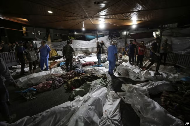 Bodies of Palestinians killed by an Israeli airstrike at the Ahli Arab hospital are gathered in the front yard of the al-Shifa hospital, in Gaza City, central Gaza Strip, Oct. 17, 2023. AP ©